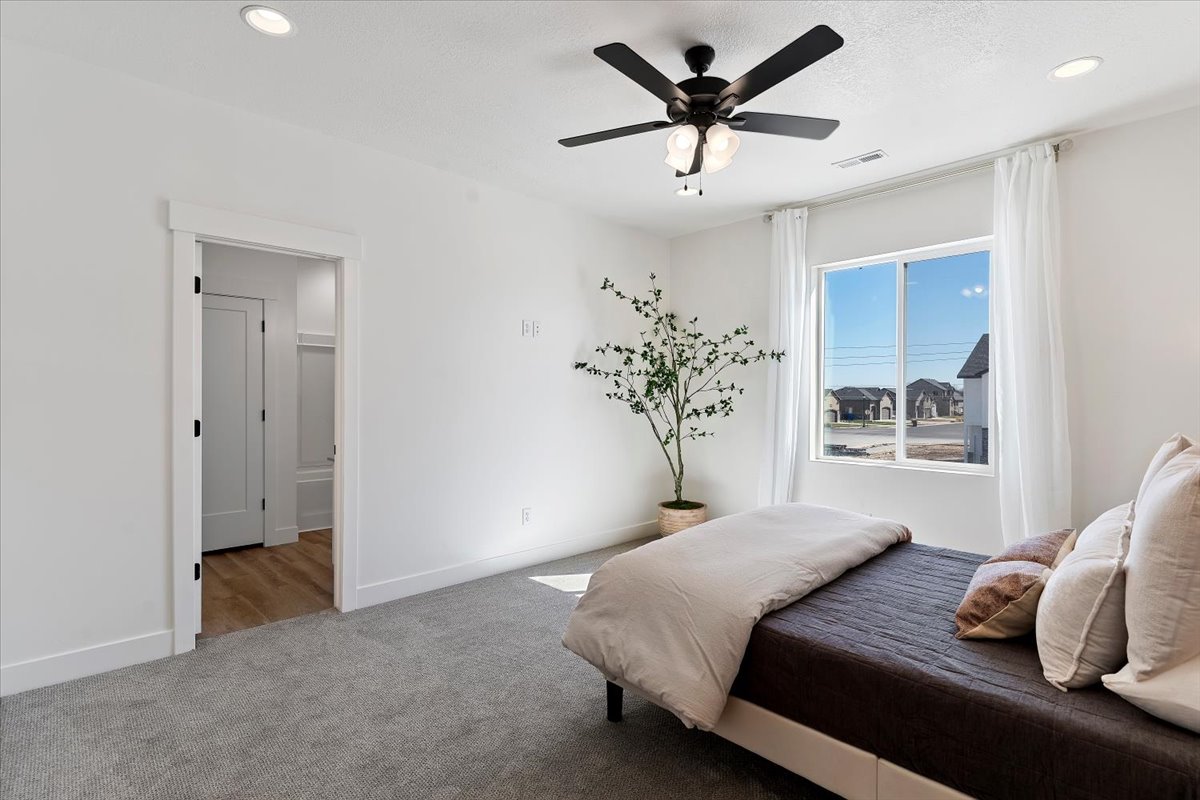 Bedroom featuring ceiling fan, carpet floors, and recessed lighting