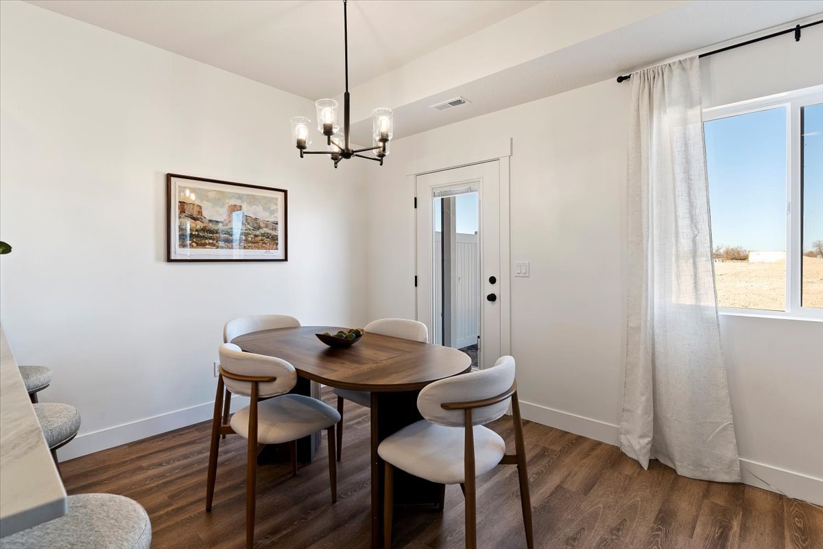 Dining space featuring dark wood-style flooring and hanging lights