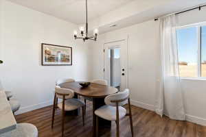 Dining space featuring dark wood-style flooring and hanging lights