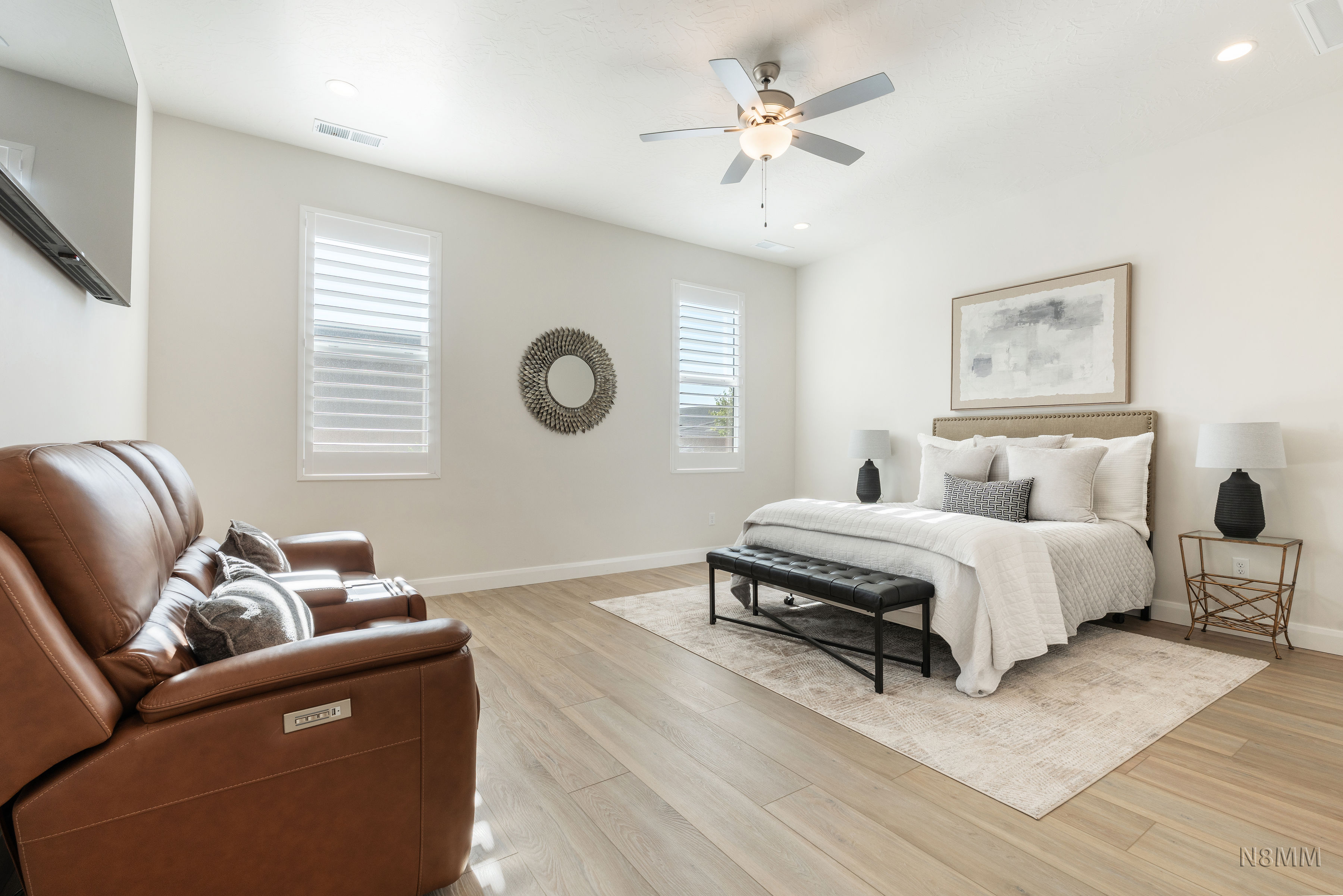 Bedroom with light wood finished floors, ceiling fan, and recessed lighting