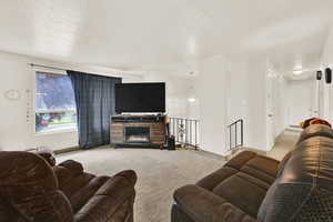 Living room featuring light colored carpet and a textured ceiling