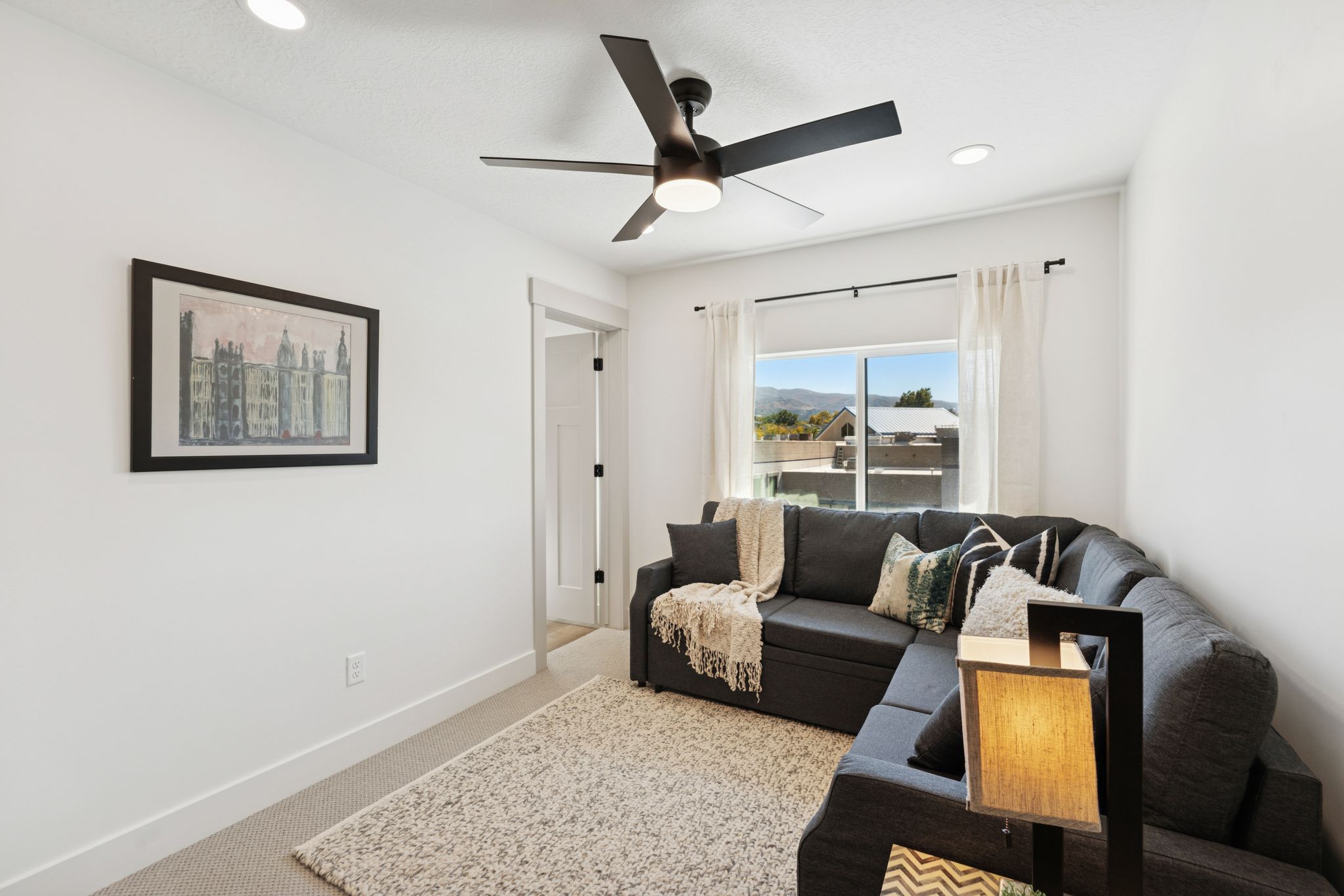 Living area with light carpet, recessed lighting, and a ceiling fan