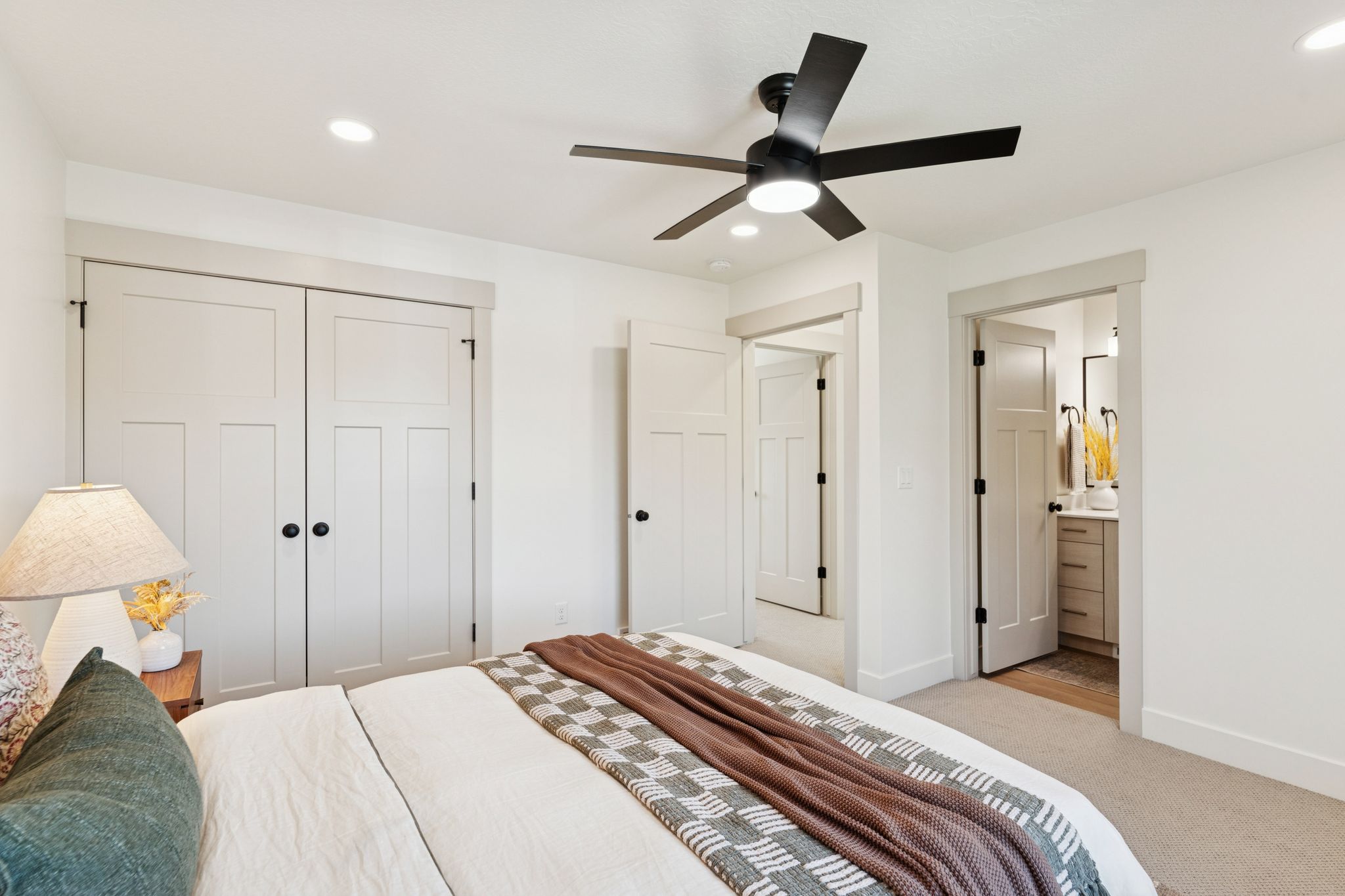 Bedroom featuring a closet, light carpet, ceiling fan, connected bathroom, and recessed lighting