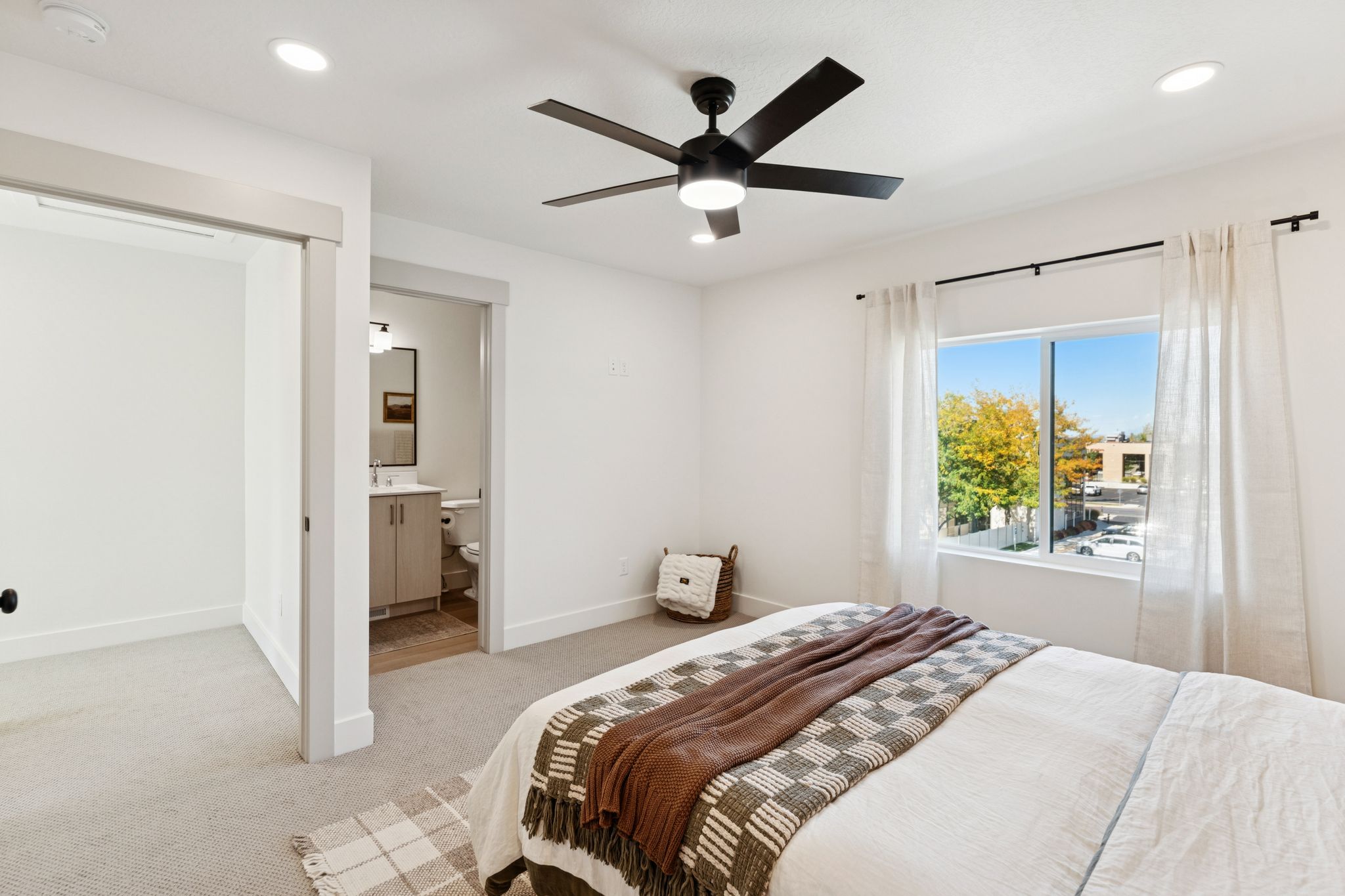 Bedroom with light carpet, recessed lighting, ceiling fan, and ensuite bath