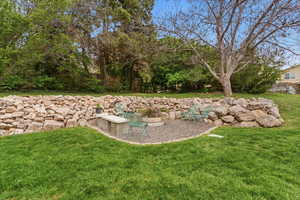 View of green lawn with a patio area