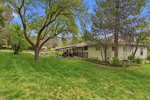 View of green lawn with a patio area