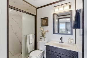 Full bathroom with a marble finish shower, vanity, and ornamental molding