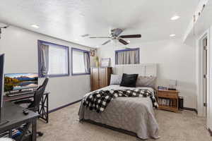 Bedroom featuring light colored carpet, an office area, a textured ceiling, a ceiling fan, and recessed lighting