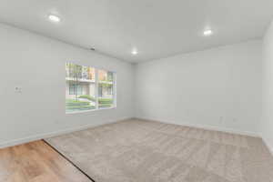 Empty room with recessed lighting and light wood-style floors