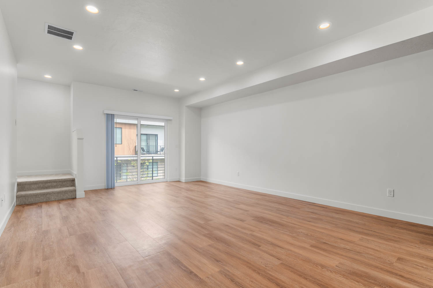 Empty room featuring light wood-type flooring and recessed lighting