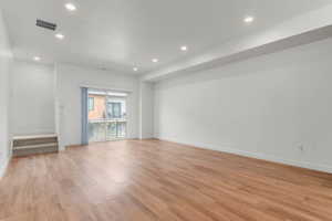 Empty room featuring light wood-type flooring and recessed lighting