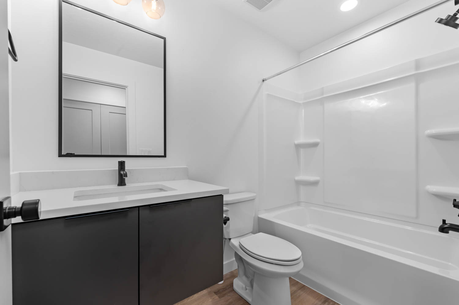Bathroom featuring vanity, shower / bath combination, and light wood-type flooring