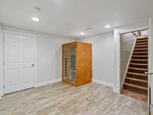 Below grade area featuring a sauna room, light wood-style floors, and recessed lighting