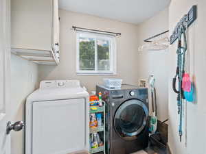 Laundry room featuring independent washer and dryer and cabinet space
