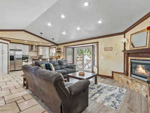 Living area with a glass covered fireplace, recessed lighting, and crown molding