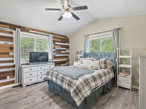 Primary Bedroom featuring light finished floors, multiple windows, ceiling fan