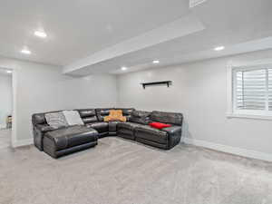 Living area with light colored carpet and recessed lighting