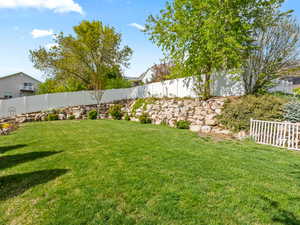 View of backyard with mature trees and flat lawn