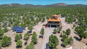 Aerial view of property and surrounding area featuring mountains and a heavily wooded area