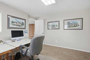 Office area featuring baseboards and light carpet