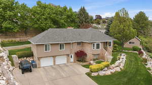 View of front of home featuring roof with shingles, a front yard, an attached garage, driveway, and brick siding