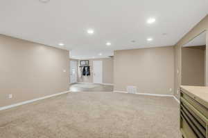 Unfurnished living room featuring recessed lighting and light colored carpet