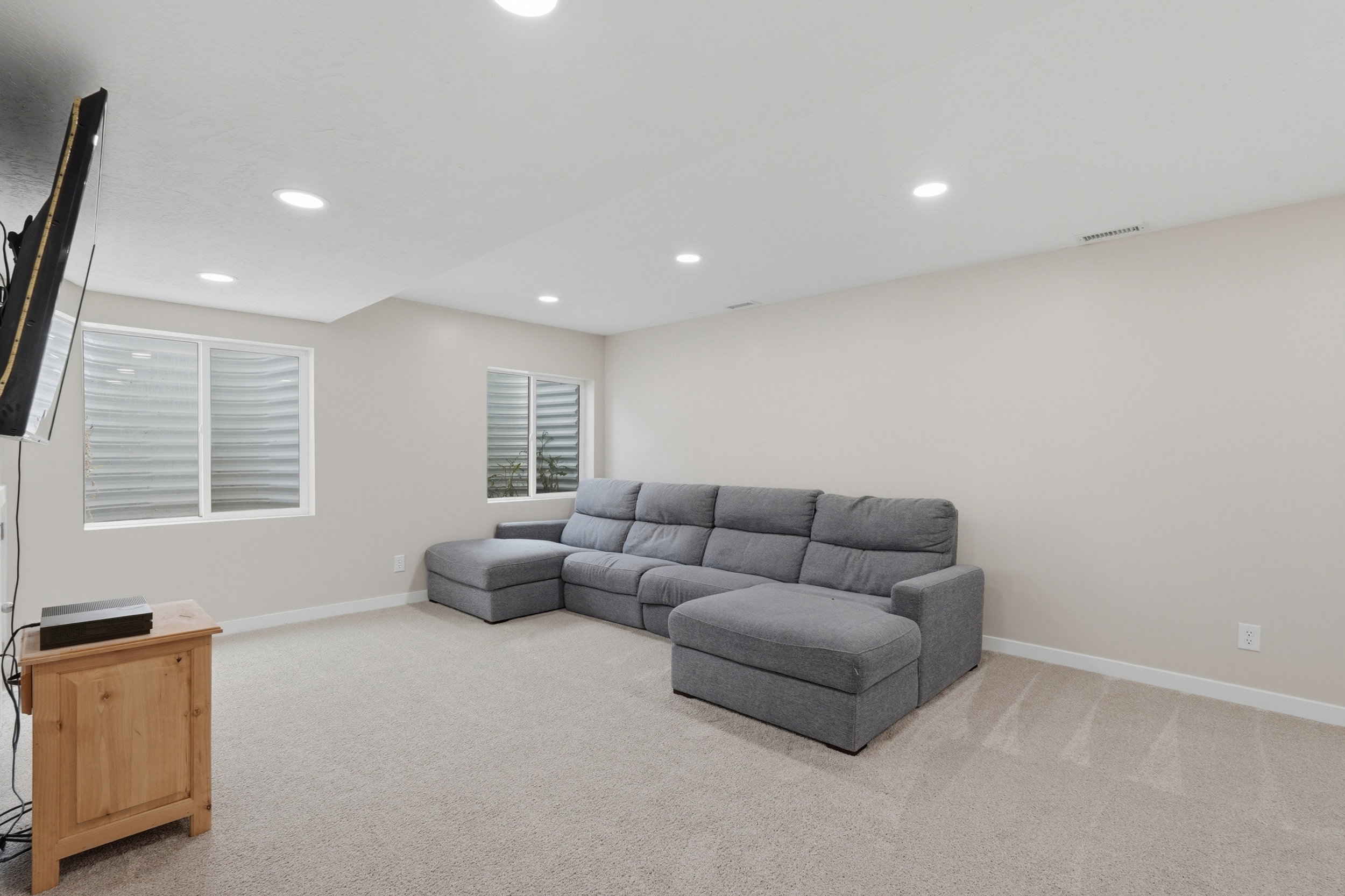Family room with light colored carpet and recessed lighting