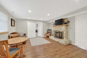 Living area featuring light wood-style flooring, a fireplace, and recessed lighting