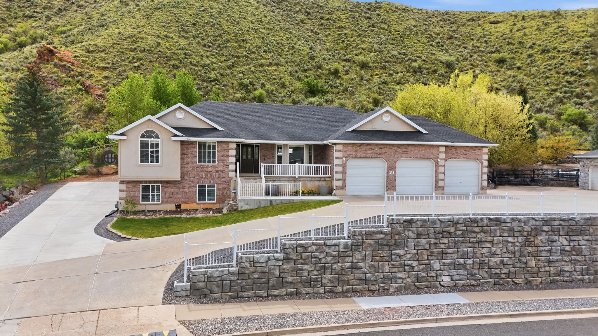 Ranch-style home with driveway, covered porch, brick siding, and a garage