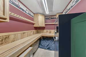 Miscellaneous room with wainscoting, wooden walls, and a paneled ceiling