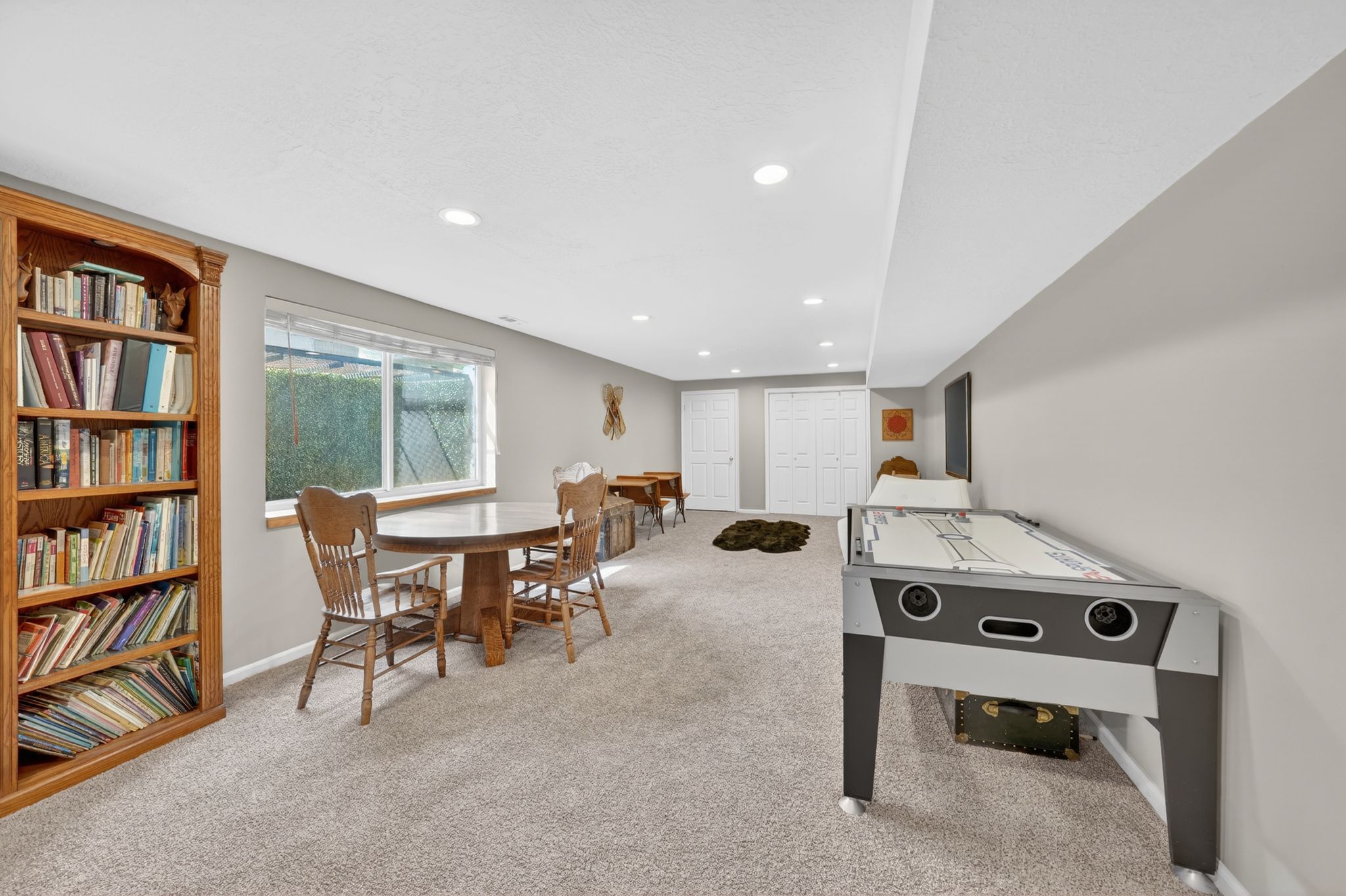 Recreation room with light carpet and recessed lighting