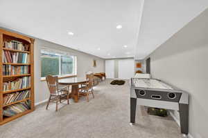 Recreation room with light carpet and recessed lighting