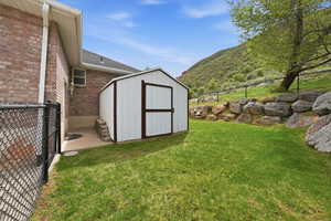 View of shed with a fenced backyard and a mountain view