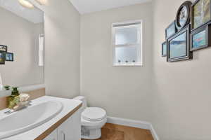 Half bath with vanity, light tile patterned floors, and healthy amount of natural light
