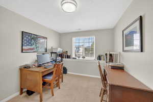 Home office with light carpet and baseboards