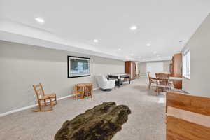 Living area with recessed lighting and light colored carpet