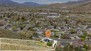 Aerial view of residential area with a mountainous background and property parcel outlined