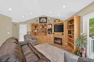 Living area with a glass covered fireplace, recessed lighting, and light tile patterned floors