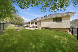 Back of house with a fenced backyard, a patio area, entry steps, and roof with shingles