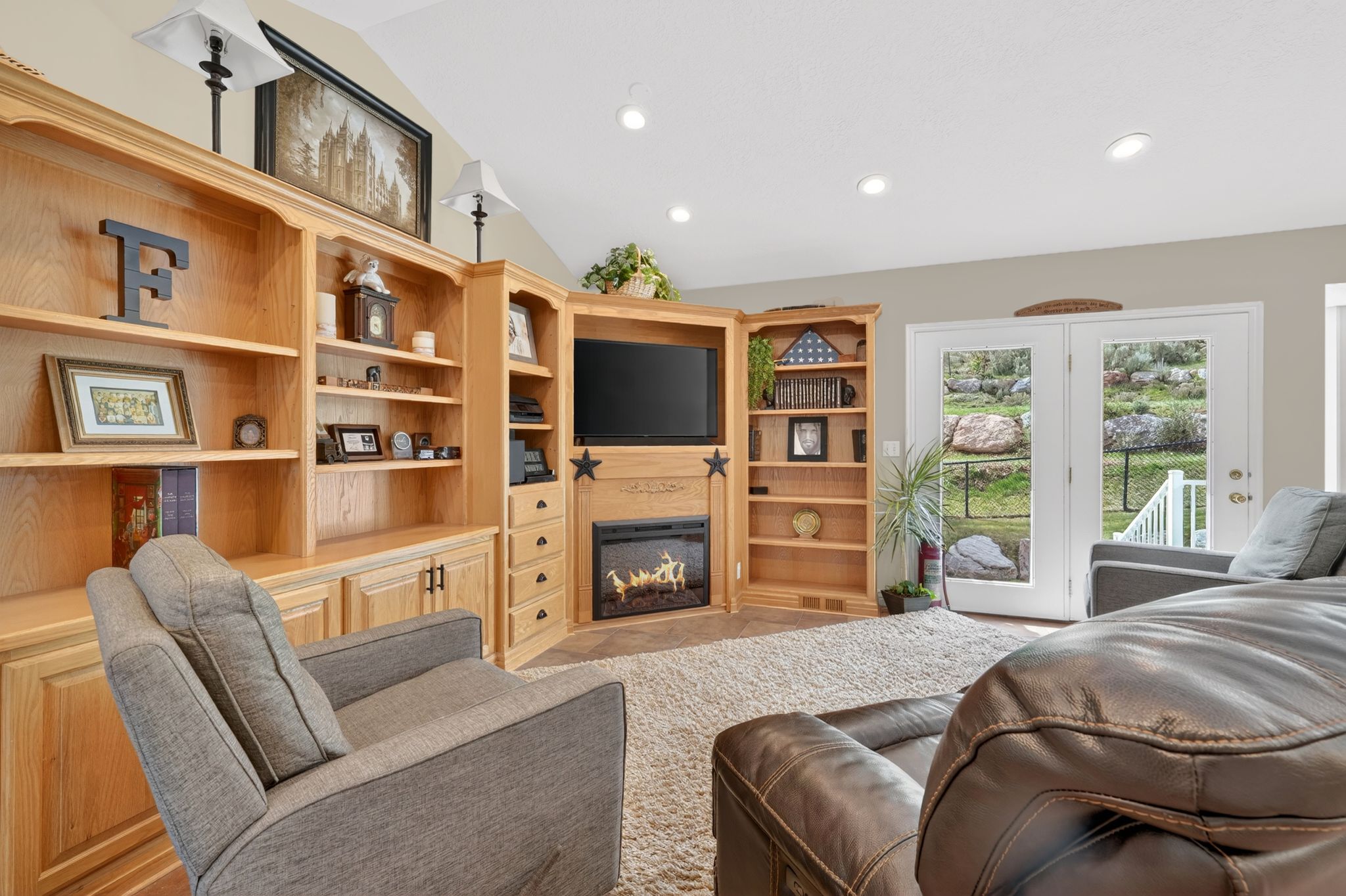 Living area featuring vaulted ceiling, recessed lighting, and a glass covered fireplace