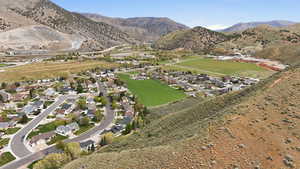 Aerial view of property and surrounding area with a mountainous background and nearby suburban area