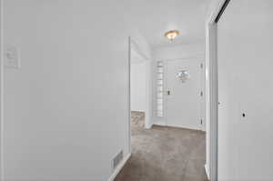 Entryway featuring light colored carpet
