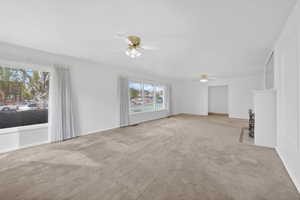 Unfurnished living room with a ceiling fan and light carpet
