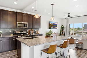 Kitchen featuring light stone counters, light wood-style flooring, and dark wood finish cabinets