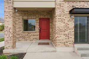 View of exterior entry featuring brick siding