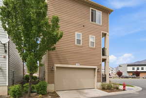 View of side of home with a garage and concrete driveway