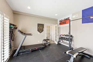 Exercise area with dark flooring, recessed lighting, and french doors