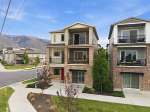 View of front of house with a balcony, board and batten siding, a residential view, a mountain view, and brick siding