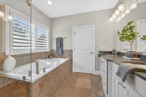 Full bathroom featuring vanity, a garden tub, and recessed lighting