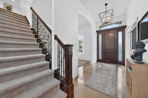 Foyer with arched walkways, hanging lights, and a high ceiling
